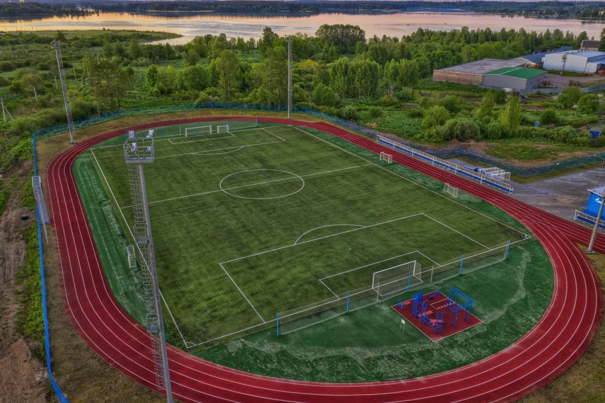 Z lotu ptaka widać boisko piłkarskie otoczone czerwoną bieżnią lekkoatletyczną.